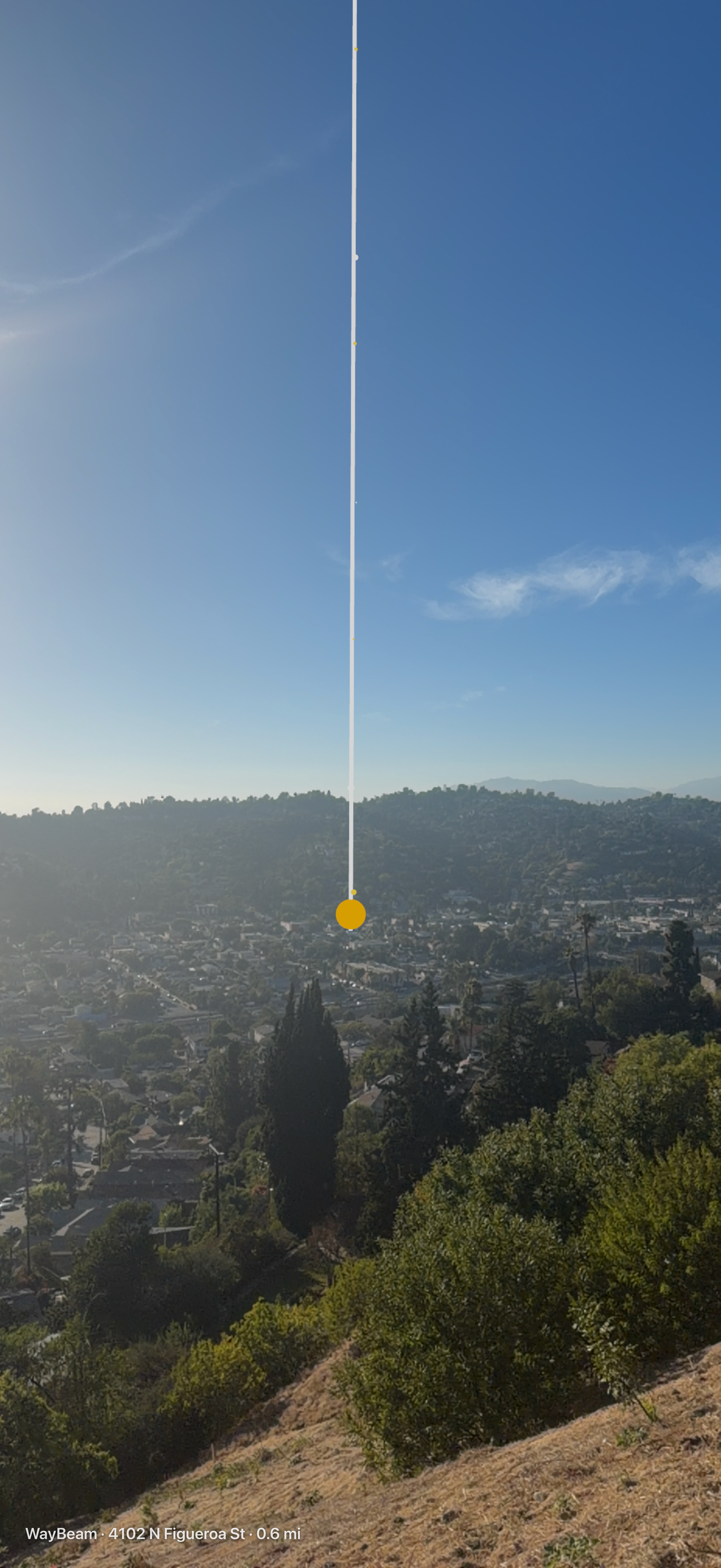 WayBeam's AR view: a column of light descending to a gold beacon over a Los Angeles valley, marked 133 W Avenue 45, 0.8 miles away.